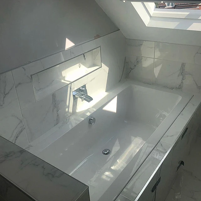 New bath with marble tiled surround